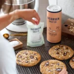 Person baking cookies with Jacobsen Salt Co. canisters nearby