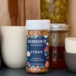 Jar of Jacobsen Co. steak seasoning displayed on a shelf with pickle jars